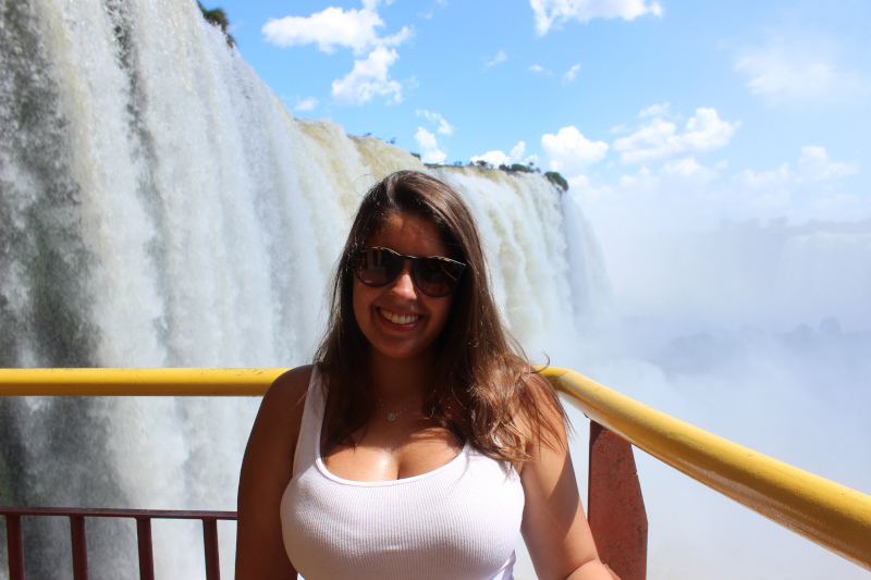 Chrys com uma cachoeira das cataratas do Iguaçu ao fundo.