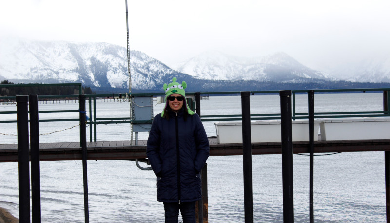 Chrys em frente a um lago com montanhas ao fundo em Lake Tahoe.
